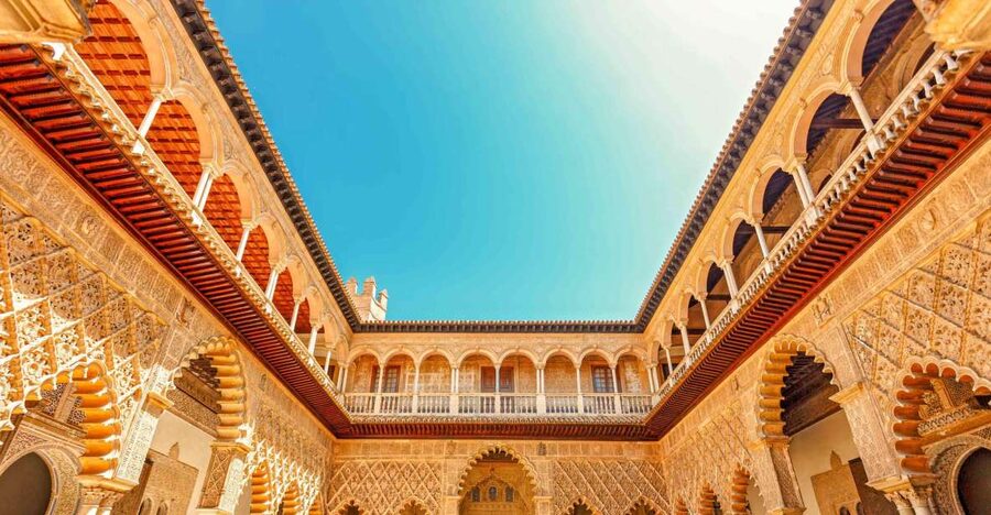 Arched galleries and still water in the Royal Alcázar of Seville
